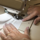A shot of a worker's hands sewing a face mask